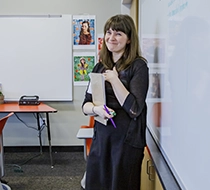 female student holding a notebook and smiling